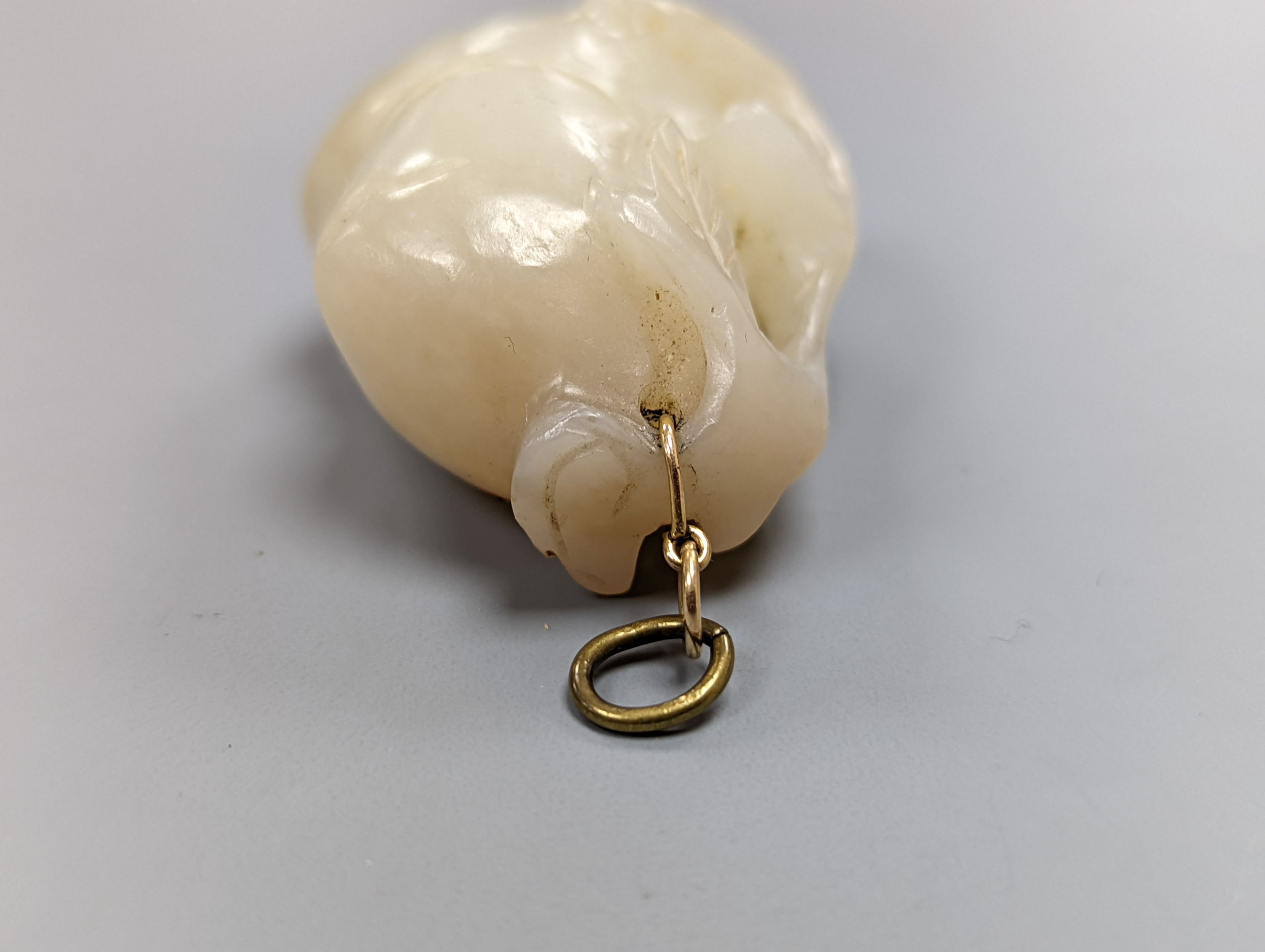 A Chinese whiteish grey jade carving of a peach branch sprig, 19th century, 4.2cm